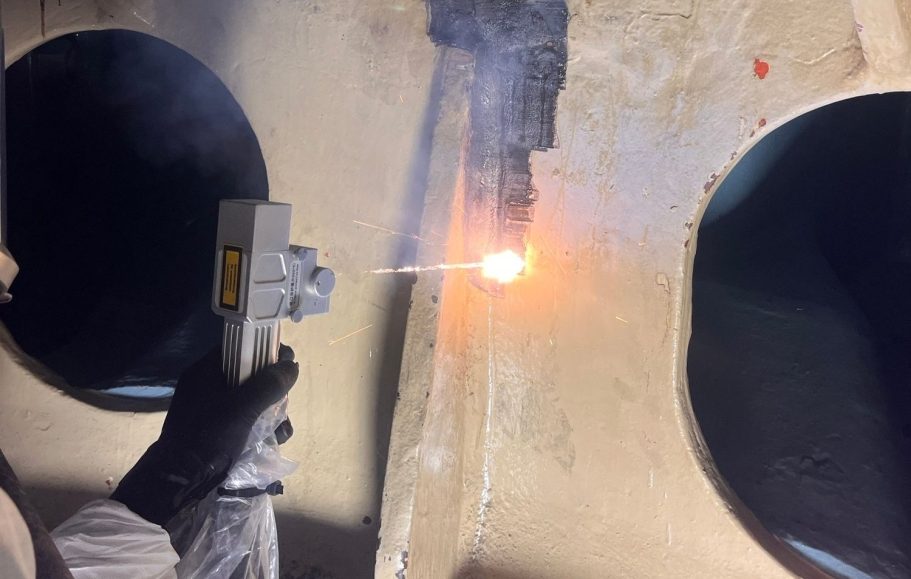 Laserentschichtung Hohlkehle Gussteil Turbinendeckel für zerstörungsfreie Prüfung Ein Arbeiter bearbeitet ein großes Turbinenteil mit einem Laser