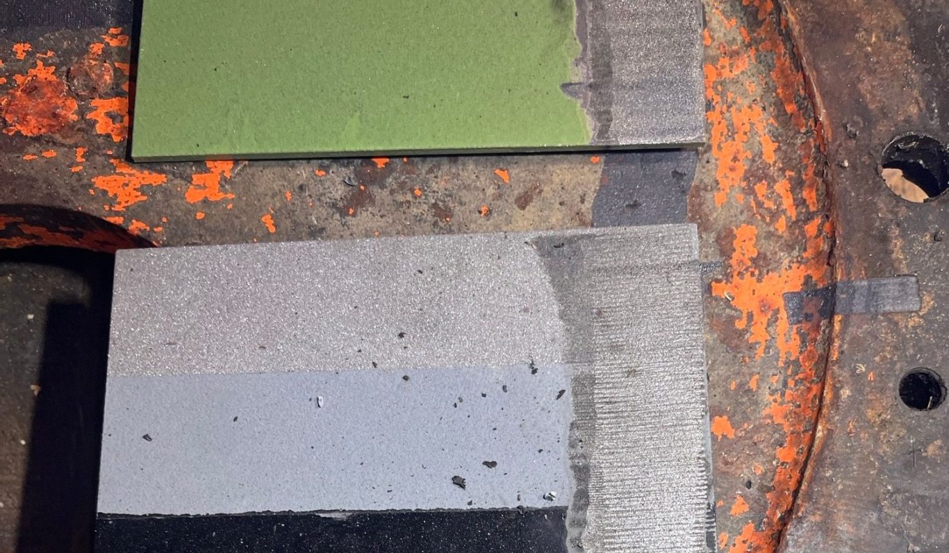 Laserentschichtung an Probeplatte (Beschichtungsapplikation "wasserberührt") Probeplatten in verschiedenen Grautönen und einem Grünton auf einer