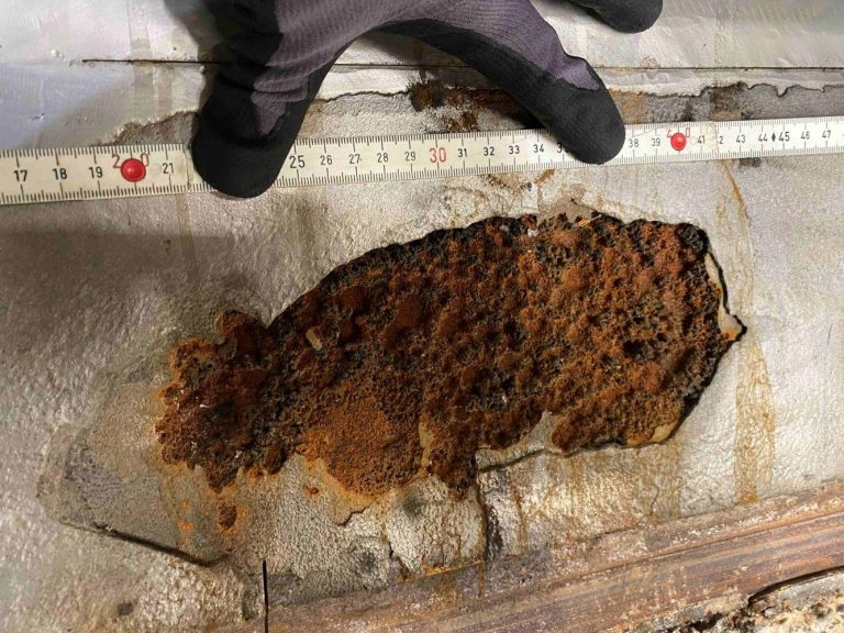 Ein Turbinenbereich mit Rostflecken, daneben ein Maßband zur Messung.